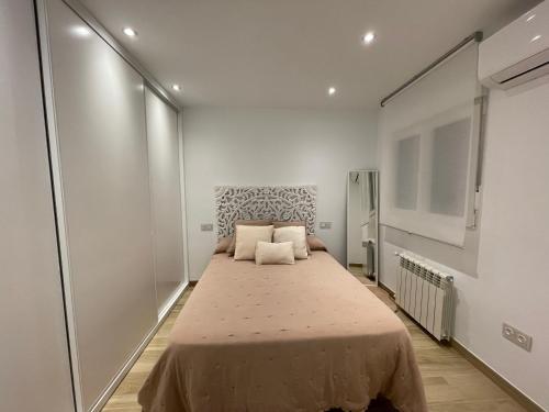 Cama grande en habitación con paredes blancas en Aixa Granada, en Granada