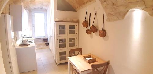 een keuken met een tafel en een kleine tafel en een keuken met een aanrecht bij Dimora Imma in Conversano