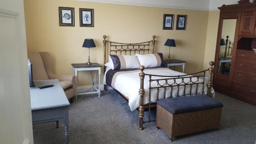 um quarto com uma cama, uma cadeira e um sofá em Ideally located Cumbrian home with stunning views em Seascale