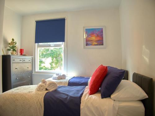 1 dormitorio con 2 camas y ventana en Lovely Large London Apartment Near Stratford en Londres