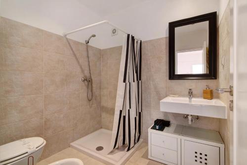 een badkamer met een douche, een toilet en een wastafel bij Large apartment in Vale do Lobo in Almancil