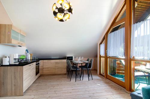 a kitchen with a table with chairs and a chandelier at Ferienwohnung Renate in Göggingen