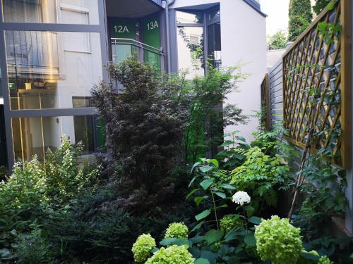 un jardin en face d'une maison ornée de plantes dans l'établissement Smart Apart Living - Wien Hauptbahnhof, à Vienne
