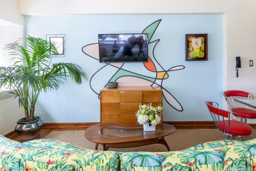 a living room with a couch and a tv at Pelican Hotel in Miami Beach