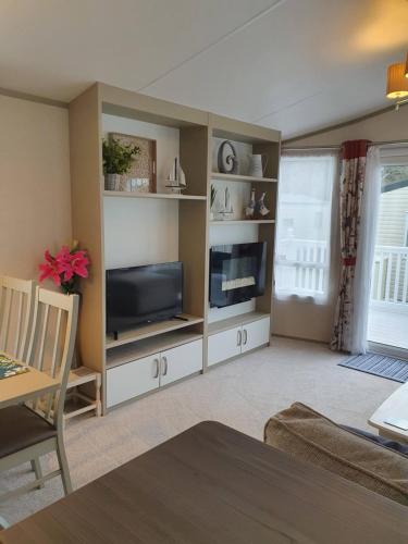 a living room with a flat screen tv and a entertainment center at K17 Lake View in Paignton