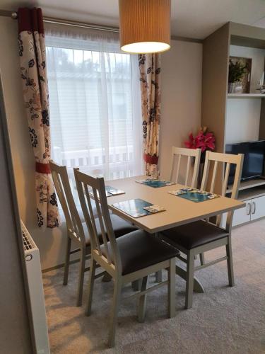 a dining room with a table and chairs and a window at K17 Lake View in Paignton