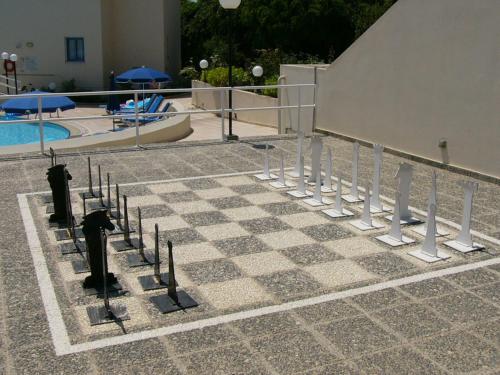 a checkerboard chess board in front of a pool at Kissos Hotel in Paphos City