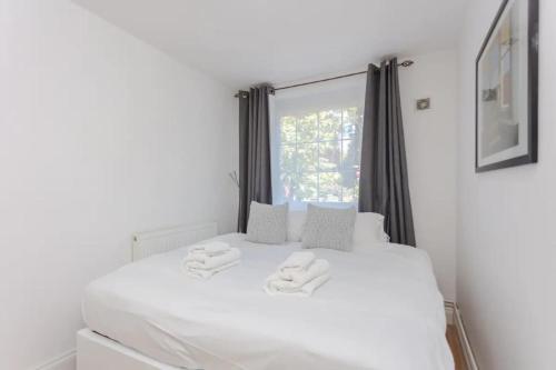 a bedroom with a white bed with two towels on it at Fabulous 2 Bedroom Apartment in London Bridge in London