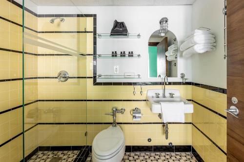 a bathroom with a toilet and a sink at Pelican Hotel in Miami Beach