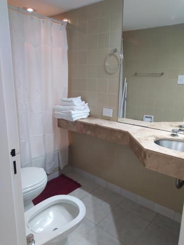 a bathroom with a toilet and a sink and a mirror at Espectacular departamento a una cuadra del obelisco (Microcentro) in Buenos Aires