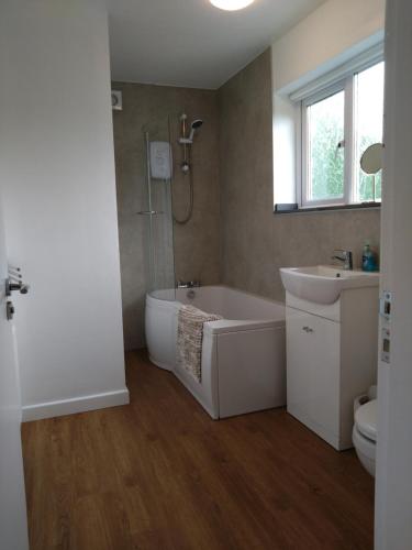 a bathroom with a tub and a sink and a toilet at Avryn - Delightful 3 bedroom cottage with stunning vistas in Mainstone