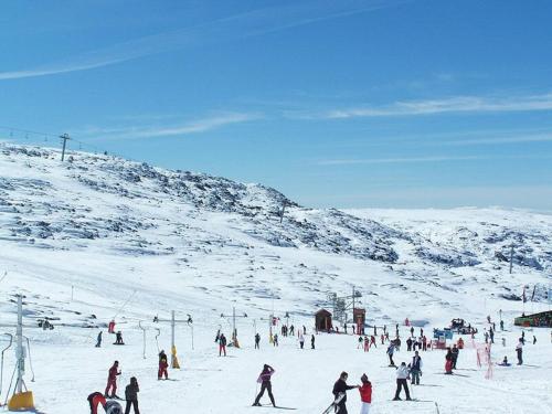 a group of people skiing on a snow covered mountain at CASA GRANDE DE JUNCAIS - SERRA DA ESTRELA in Fornos de Algodres