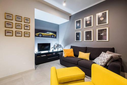 sala de estar con sofá negro y silla amarilla en Harinero, characteristic apartment in the center, en SantʼAgata Bolognese