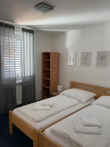 a bedroom with two beds and a window at Mikulov Inn - hotel Zeme in Mikulov