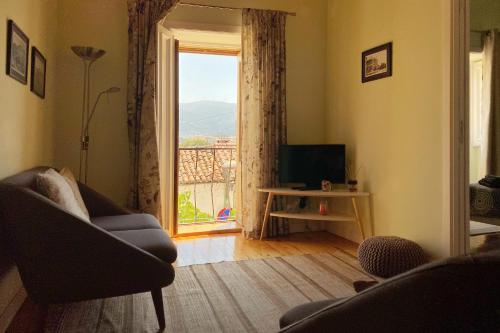 a living room with a couch and a window at Casa d'Avó in Miranda do Corvo