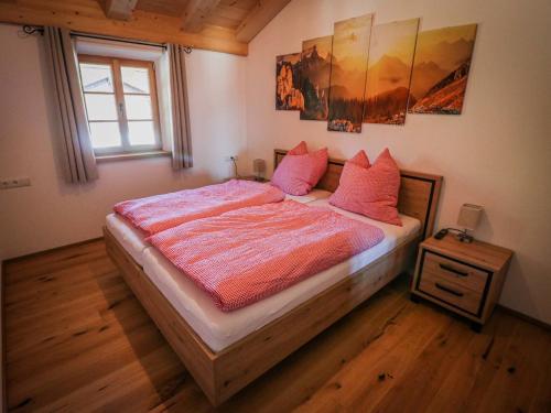 a bedroom with a bed with pink pillows and a window at Ferienwohnungen Koller in Bad Aibling