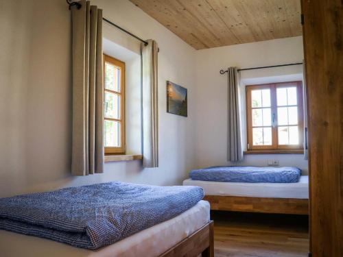 two beds in a room with two windows at Ferienwohnungen Koller in Bad Aibling