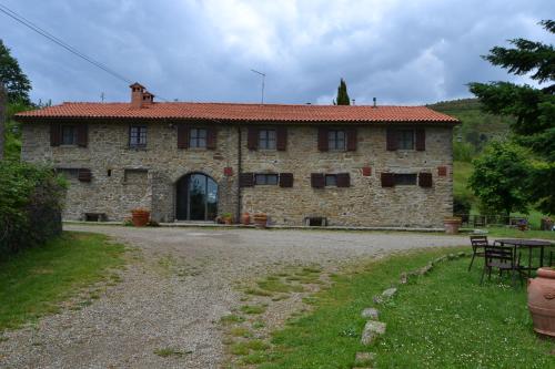 um grande edifício de pedra com uma mesa em frente em Two-room apartment in Tuscan rustic style em La Lama