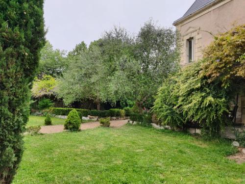 a yard of a house with trees and bushes at VILLA DE SOUZA in Bouillé-Loretz