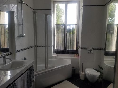 La salle de bains est pourvue d'une baignoire, de toilettes et d'un lavabo. dans l'établissement VILLA DE SOUZA, à Bouillé-Loretz