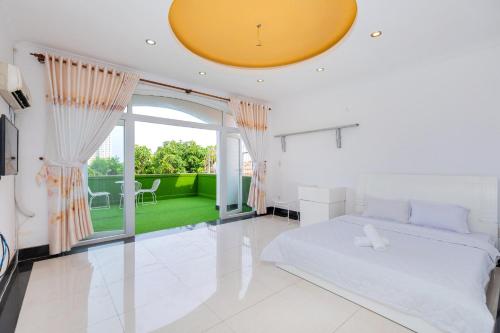 ein weißes Schlafzimmer mit einem Bett und einem großen Fenster in der Unterkunft Villa Hai An in Vũng Tàu