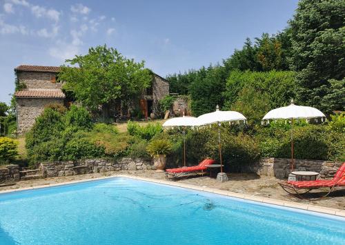 - une piscine avec 2 parasols et 2 chaises dans l'établissement Mas Des Terrasses, à Aujac