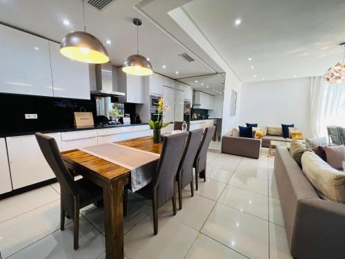 a kitchen and living room with a wooden table and chairs at Melrose Beαch Aρραrt Pοοl Vieω in Casablanca