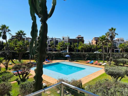 a swimming pool in a resort with a palm tree at Melrose Beαch Aρραrt Pοοl Vieω in Casablanca