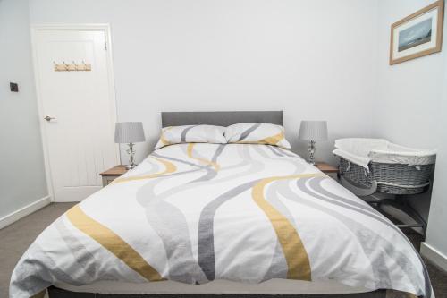 1 dormitorio con 1 cama con edredón amarillo y blanco en JOIVY Family house with courtyard in Hoylake en Hoylake