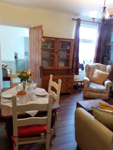a dining room with a table and chairs and a couch at Rose Cottage in Telford