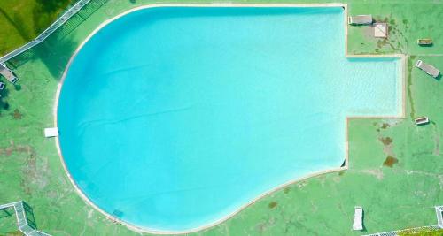 an overhead view of a large blue swimming pool at Jolie petite Villa sur une presqu’île in Le Gosier