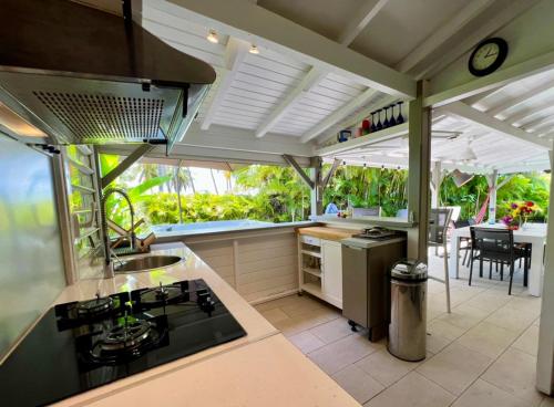 a kitchen with a stove and a counter top at Jolie petite Villa sur une presqu’île in Le Gosier