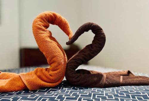 two towels forming a heart on a bed at Jolie petite Villa sur une presqu’île in Le Gosier