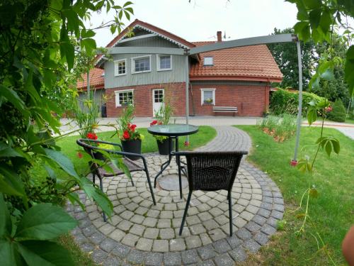 a patio with two chairs and a table in a yard at Mono House in Rusnė