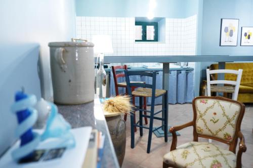 a kitchen with a counter with chairs and a table at Vicol 8 di Nicabell vacanze in Monteleone di Puglia