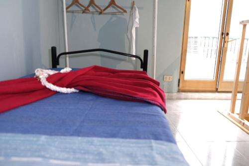 a bed with a red blanket on top of it at Vicol 8 di Nicabell vacanze in Monteleone di Puglia
