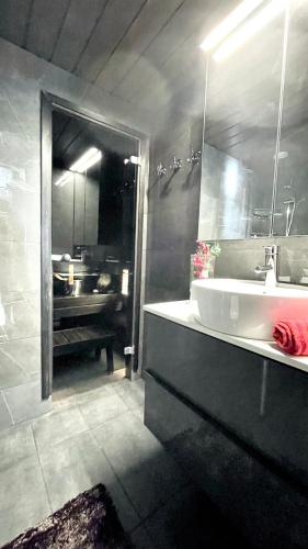 a bathroom with a sink and a mirror and a tub at Ruka Chalet Petit Oliver in Ruka