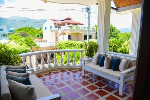 a porch with two white benches on a balcony at VG Villa Gloria in Santa Marta