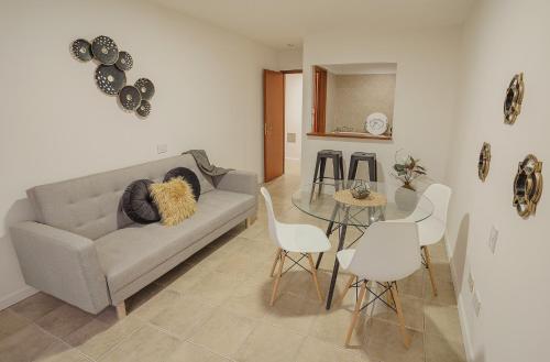 uma sala de estar com um sofá e uma mesa em Isla Bonita Suites em Ushuaia