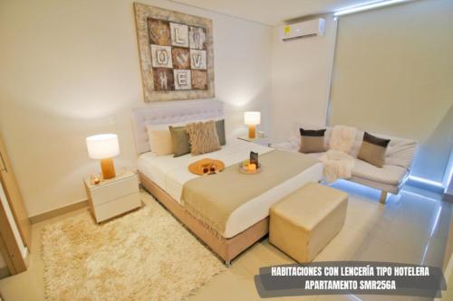 1 dormitorio con 1 cama blanca grande y 1 sofá en Apartamentos Reserva del Mar - Frente al Mar by SOHO, en Santa Marta