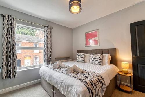 a bedroom with a large bed and a window at Guest Homes - Gillam House in Worcester