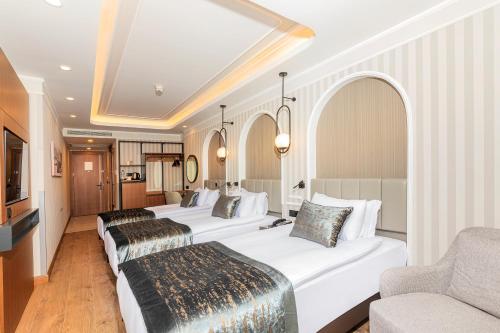 a hotel room with four beds and a couch at Mukarnas Pera Hotel in Istanbul