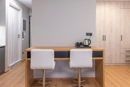 a kitchen with a wooden table and two white chairs at Ethereal Athεns in Athens