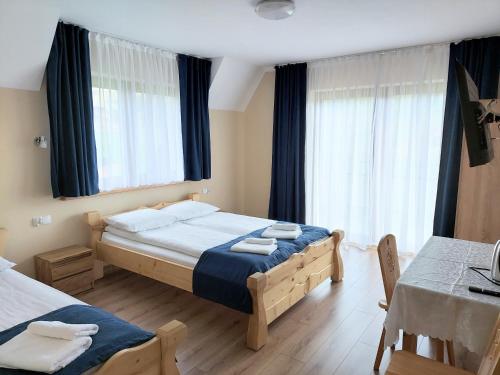 sypialnia z 2 łóżkami, stołem i krzesłami w obiekcie Willa u Polczyków w mieście Białka Tatrzanska