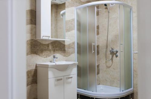 a bathroom with a sink and a shower at Class Apartment in Brčko