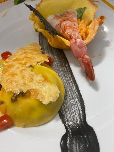 a plate with a piece of food and a spoon at Hotel Parco Delle Agavi in Ischia