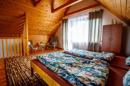 um quarto com uma cama num quarto de madeira em Domek na skarpie em Rybno