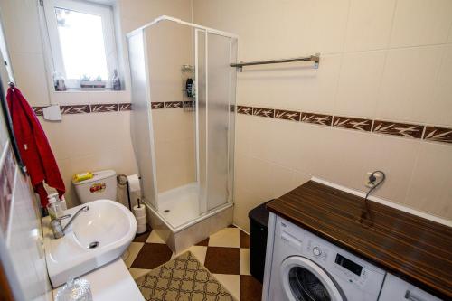 a bathroom with a sink and a washing machine at Domek na skarpie in Rybno