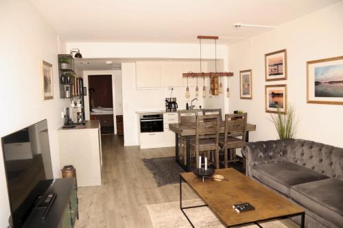 a living room and kitchen with a couch and a table at Lägenhetshotell Varvet in Ellös