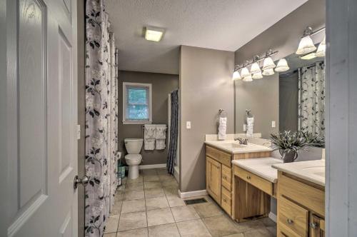 a bathroom with two sinks and a toilet and a mirror at Peaceful Sevierville Home with Private Hot Tub! in Sevierville